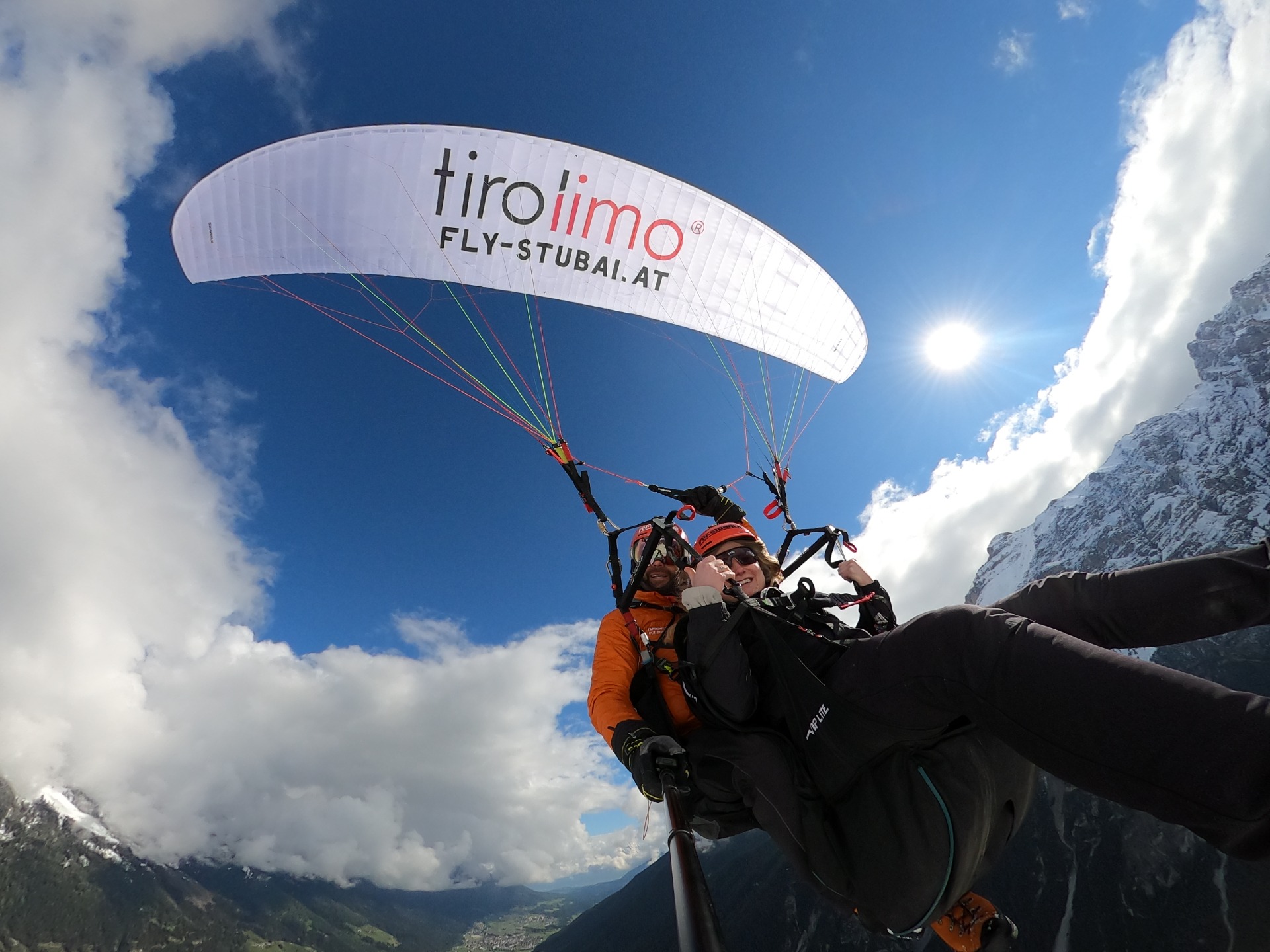 Steiler Blick nach oben beim Tandem-Paragliding mit Schirm und Sonne über Tirol